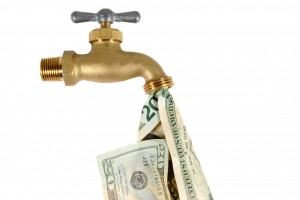 Water tap dripping dollar bills, Water waste concept